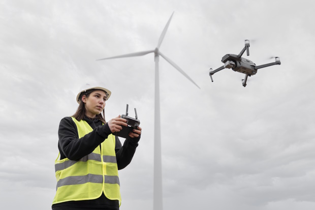 Web.medium-shot-woman-engineer-controlling-drone | BouwTotaal Ingenieur die een drone bestuurt.
