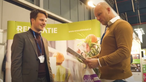 twee mannen die aan het praten zijn de ene heeft een krant vast