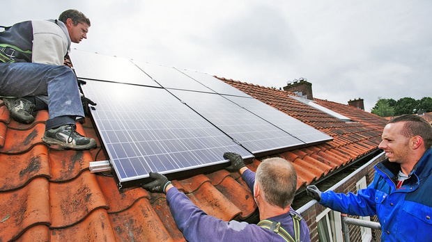 Installatie zonnepanelen door drie monteurs