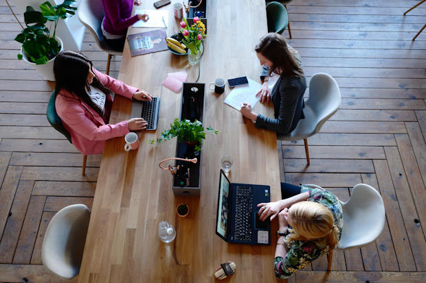 Drie Vrouw Zittend Op Een Witte Stoel Voor een tafel