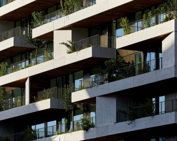 Bomen en planten op de balkons en gevel van de woontoren van Wonderwoods.