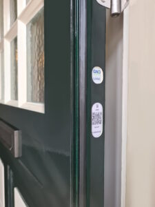 GND-zekerheidslabel met QR-code op de scharnierzijde van de deur.
