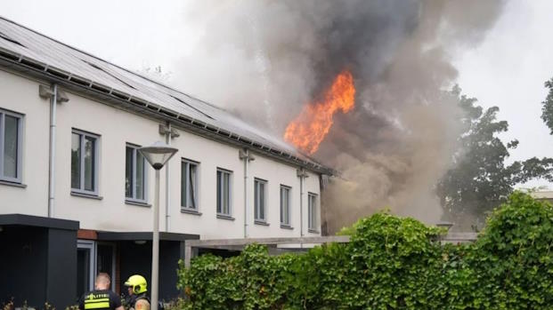 Brand bij een rij verduurzaamde woningen met doorlopende zonnepanelen in Arnhem.